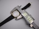 Top-down view of the Citizen Eco-Drive watch being measured by a digital caliper, displaying a case diameter of 36.14mm.