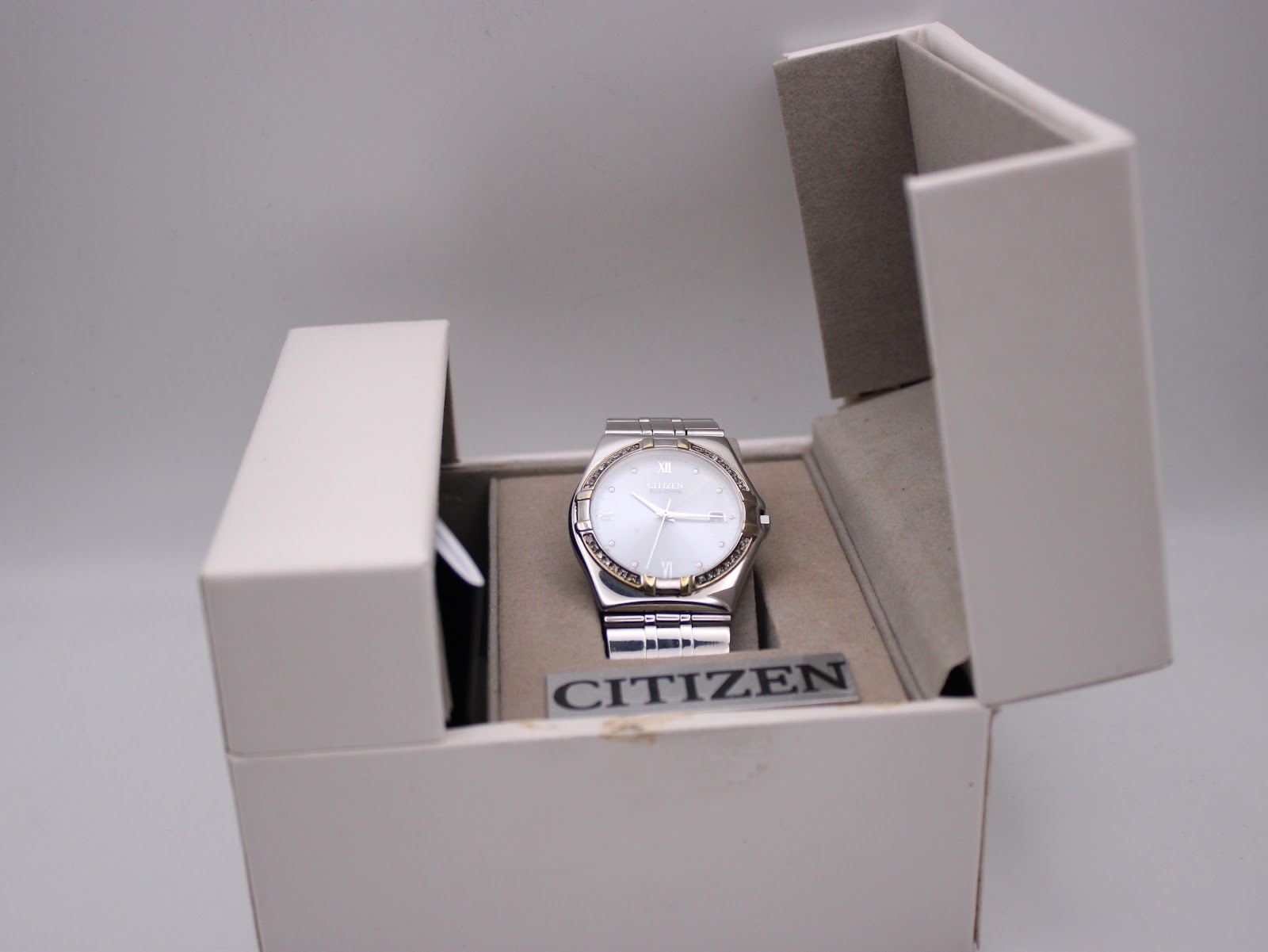 Front view of the Citizen Eco-Drive watch in its original white box, angled slightly.