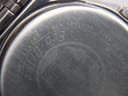 Extreme close-up of the Citizen watch case back, revealing the serial number 'E110-S001421 HSB 260772'.
