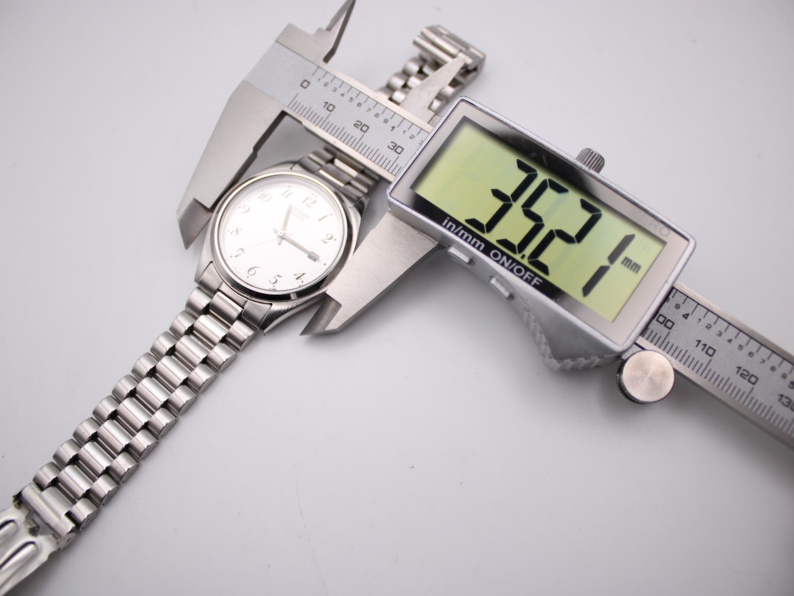The Citizen watch being measured by a digital caliper, showing a case diameter of 35.2mm.