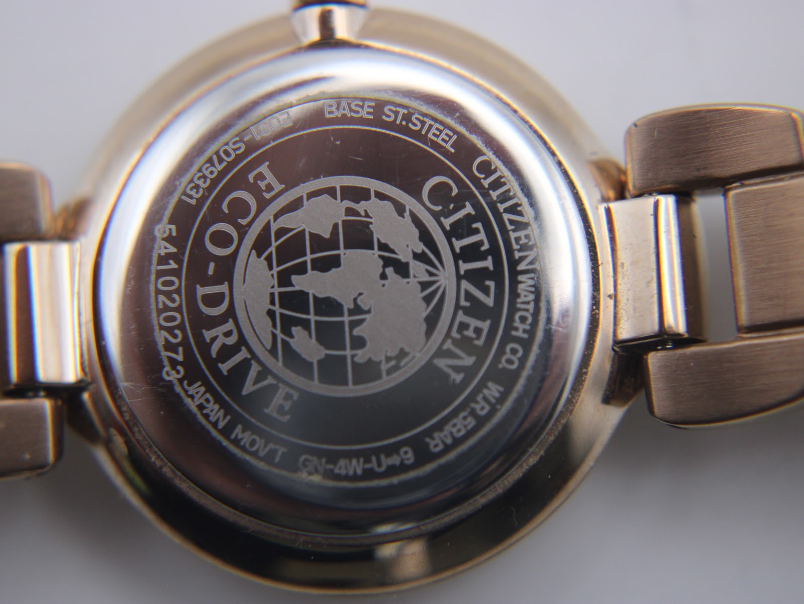 Close-up of the Citizen Eco-Drive watch case back, showing engraved model number S079331, serial number, Eco-Drive logo, and 'W.R. 5BAR'.