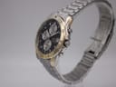 Angled side view of the Citizen watch showing the crown, pushers, and integrated bracelet.