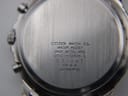 Detailed close-up of the brushed stainless steel case back of the Citizen watch with engravings.