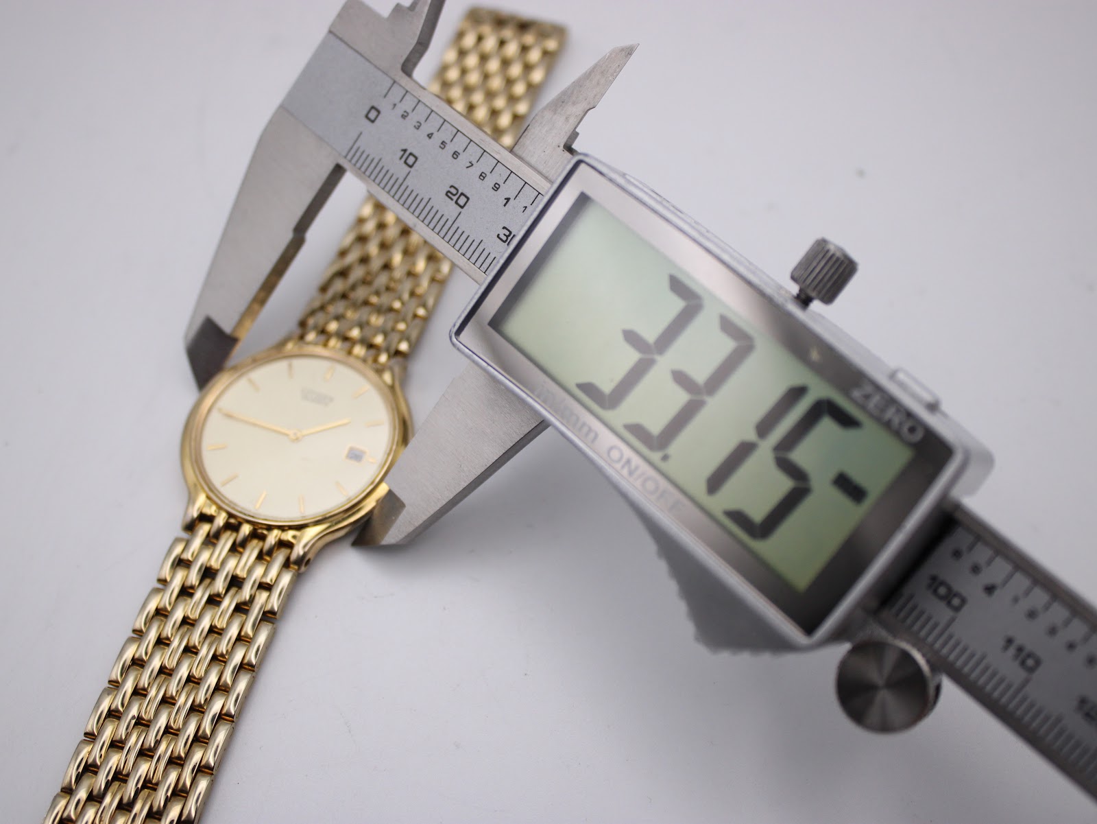 Digital caliper measuring the case diameter of the Citizen watch, displaying 33.15mm.