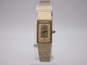 Front view of the gold-tone Citizen quartz watch with rectangular case and champagne dial on a clear stand.
