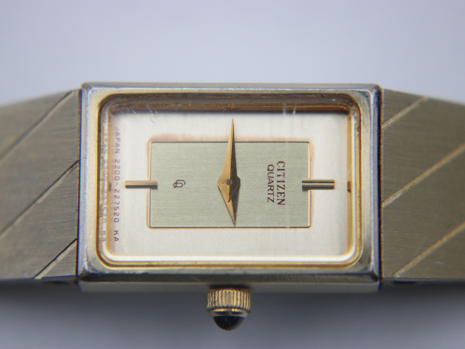 Close-up front view of the Citizen watch dial, showing the champagne face, gold hands, and "CITIZEN QUARTZ" text.