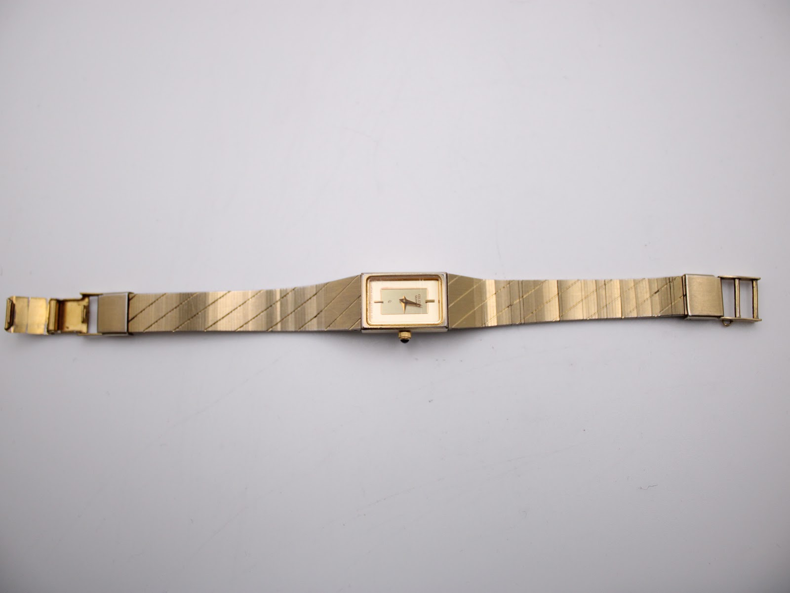 Full overhead view of the Citizen watch with its gold-tone textured bracelet laid flat, showing the front.
