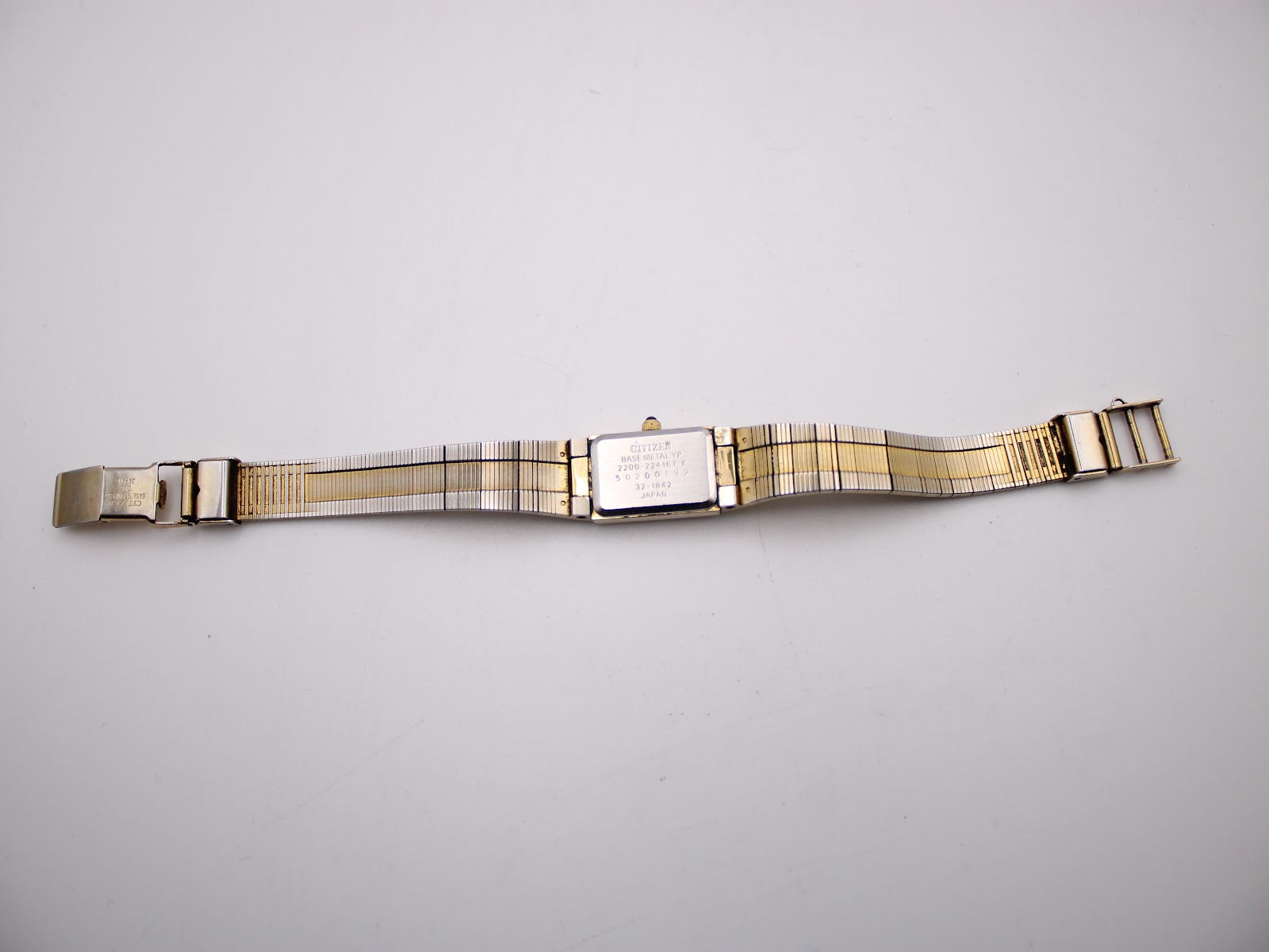 Full overhead view of the Citizen watch with its gold-tone textured bracelet laid flat, showing the case back.