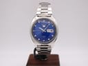 Front-on view of the Seiko 6119-8273 automatic watch on a display stand, showcasing its vibrant blue dial and stainless steel case.