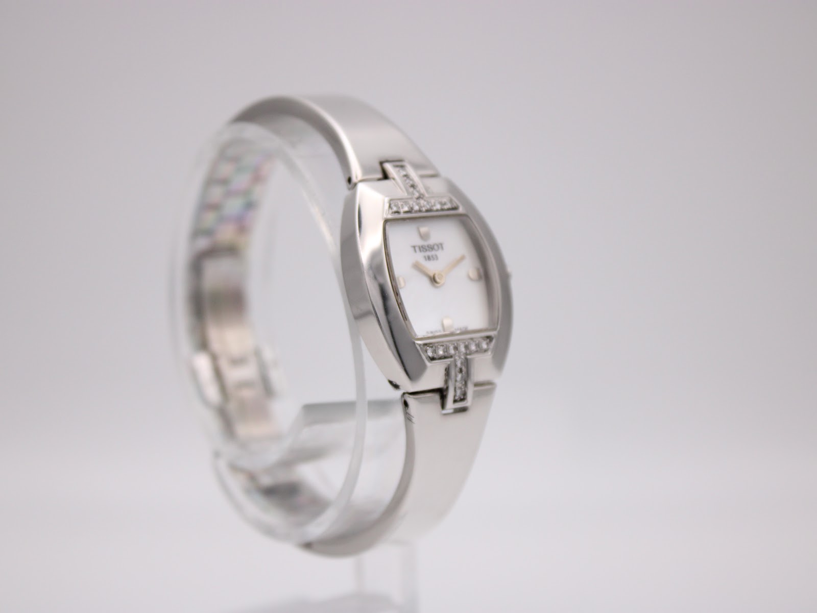 Another angled side view of the Tissot L953 watch, highlighting the polished stainless steel and diamond detailing.