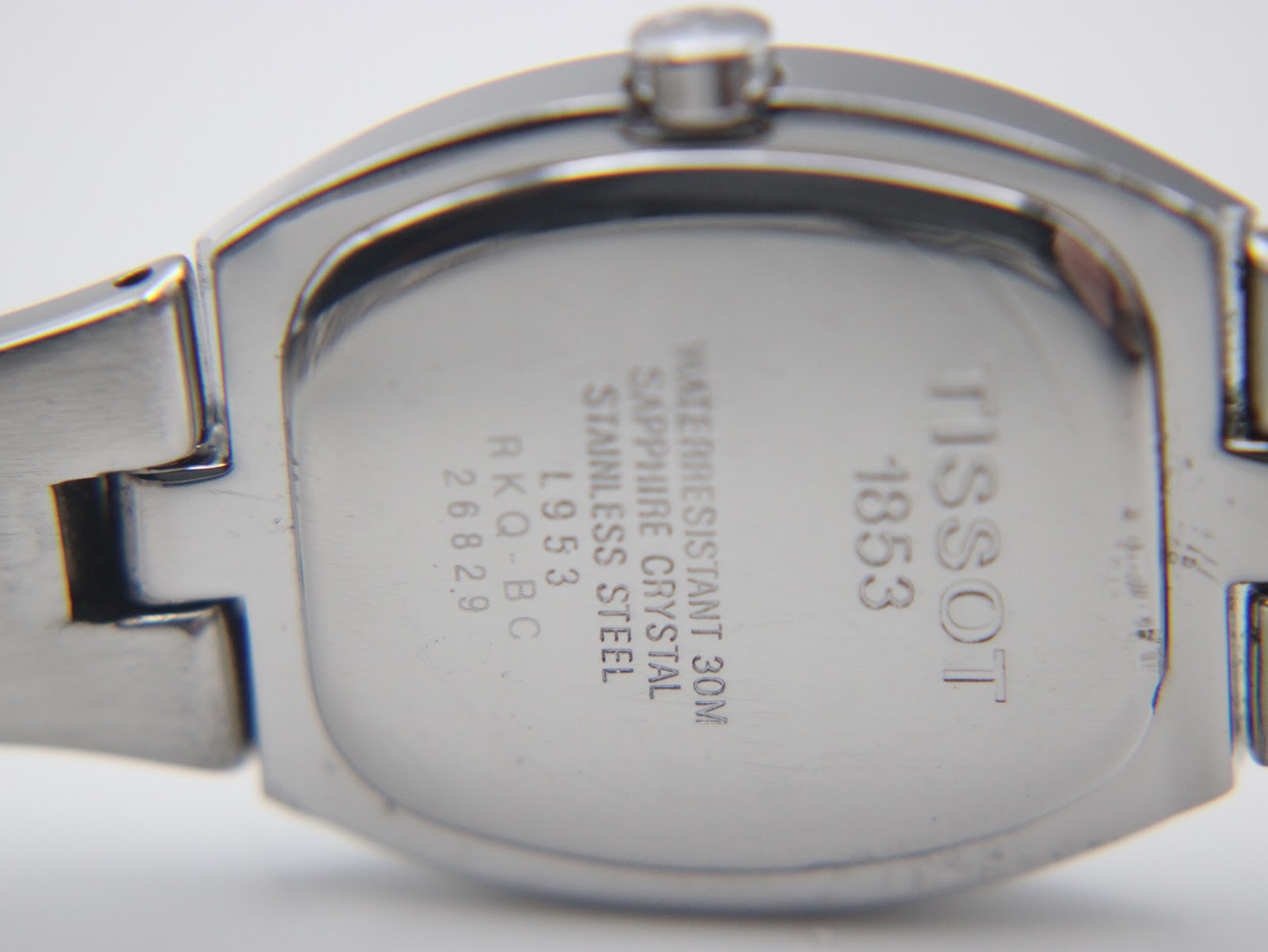 Close-up of the case back engraving, showing "Tissot 1853", model L953, serial 26829, and "sapphire crystal waterresistant 30m stainless steel".