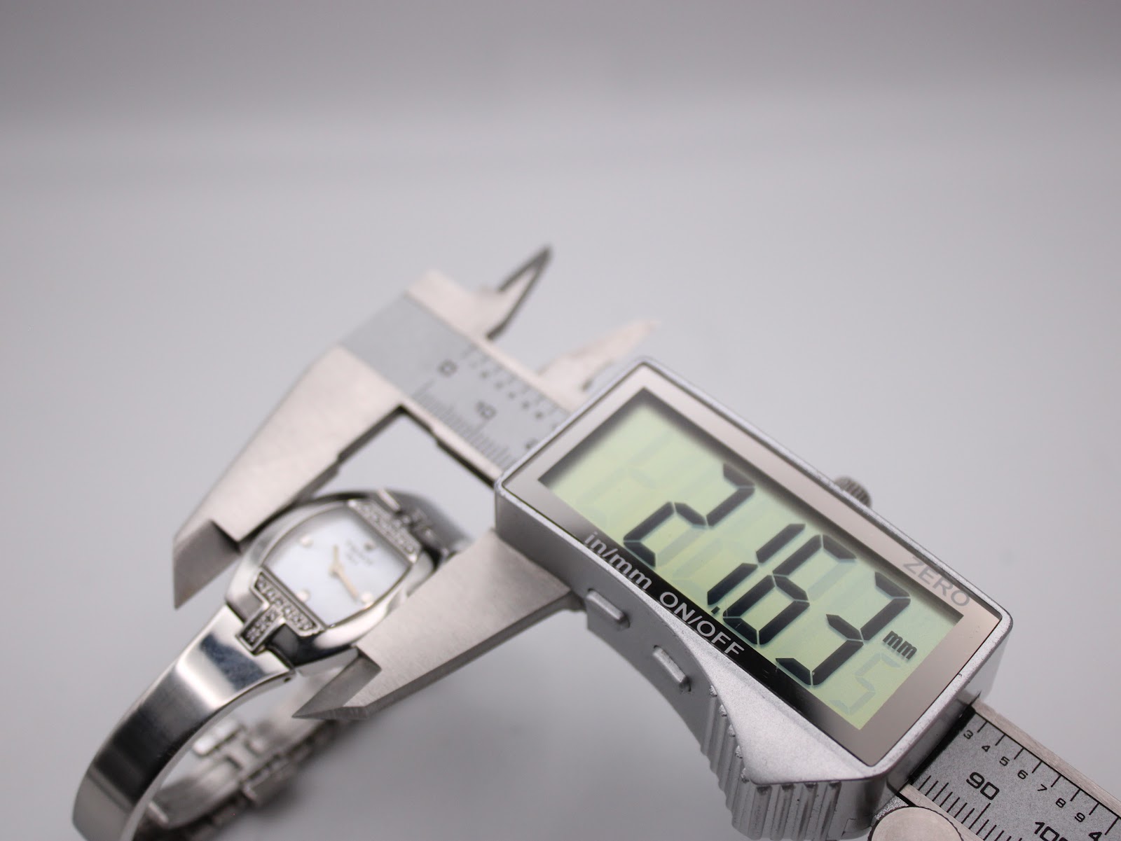 Digital caliper measuring the case diameter of the Tissot L953 watch at 21.67mm.