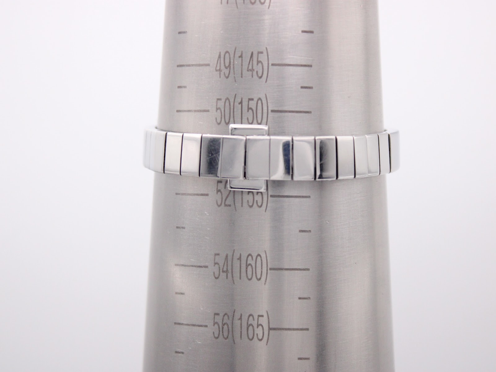 The integrated bracelet of the Tissot watch on a wrist sizing gauge, indicating a circumference of 15.5cm.