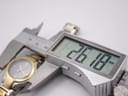 Digital caliper measuring the watch case diameter at 26.18mm.