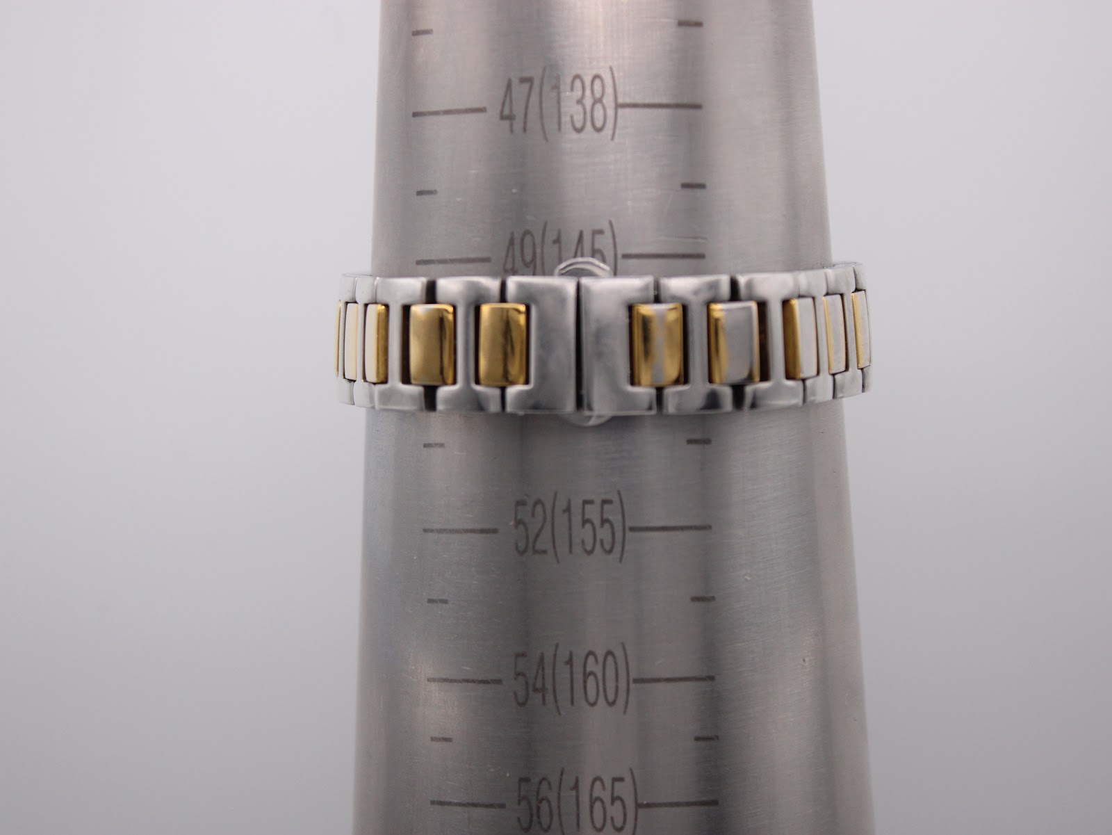The two-tone bracelet wrapped around a wrist sizing cone, showing a wrist circumference of approximately 14.5cm.