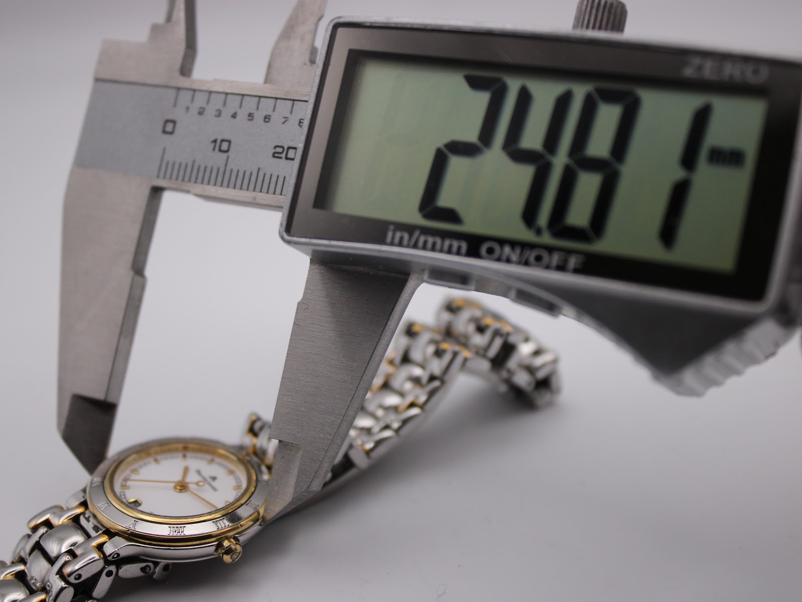 Digital caliper measuring the case diameter of the watch, displaying 24.81mm.