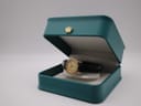 The Tissot watch displayed inside an open teal green presentation box with a gold crown emblem.