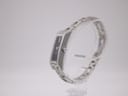 Side view of the Gucci 110 watch on a display stand, highlighting the slim profile and integrated bracelet design.