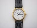 Overhead front view of the Tissot C 212 watch lying flat, displaying the white dial, gold-tone case, and black crocodile-grain leather strap.