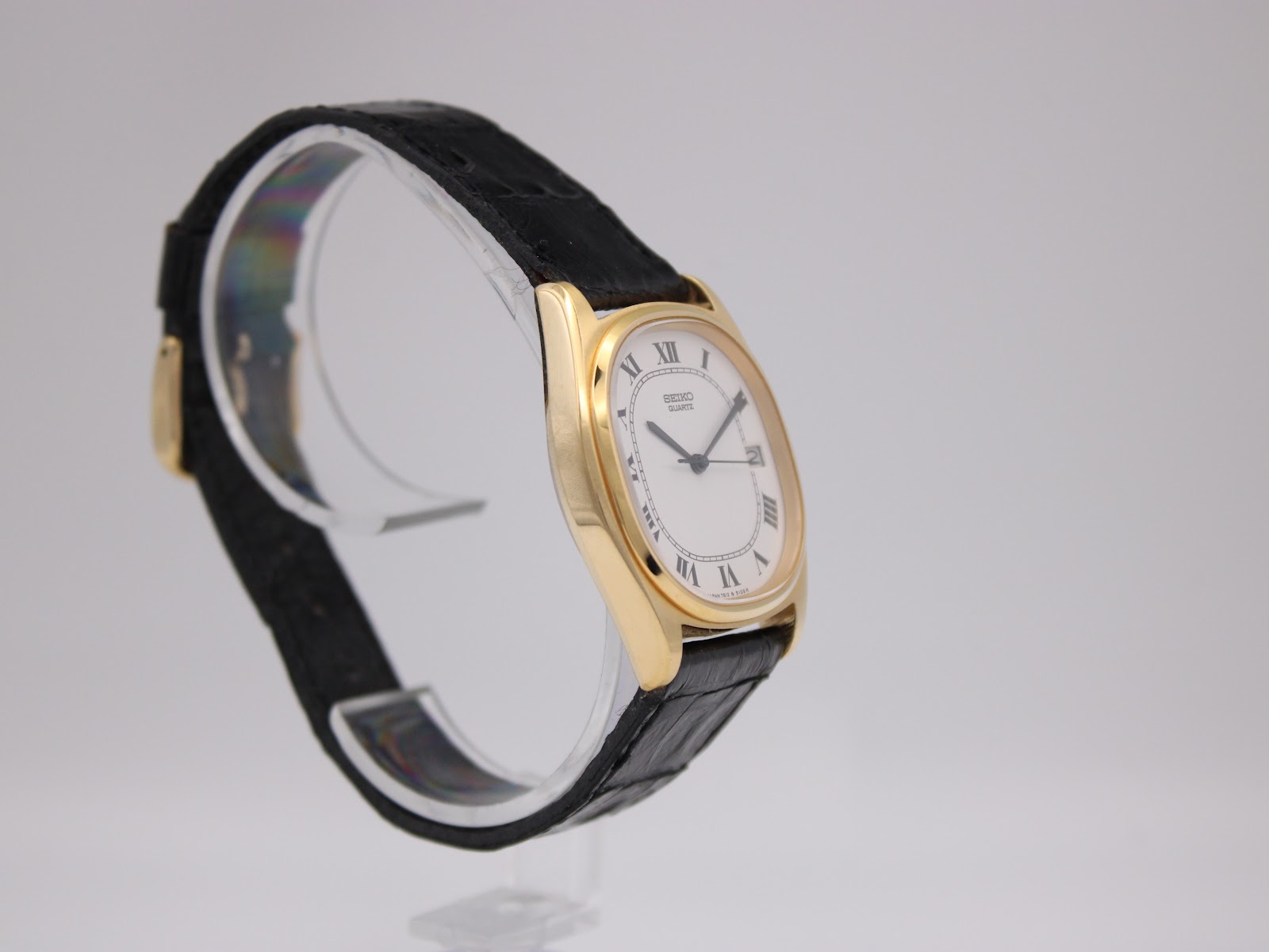 Another angled side view of the Seiko watch, highlighting the curvature of the tonneau case and the texture of the strap.
