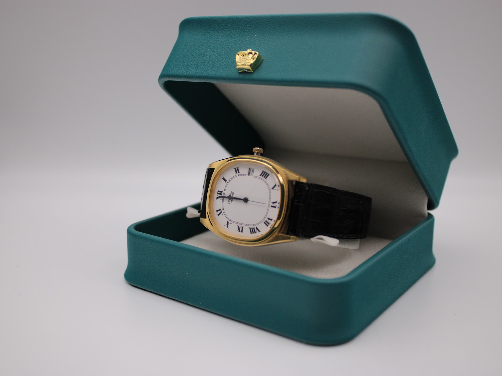 The Seiko watch presented inside a teal-coloured decorative display box with a crown emblem on the lid.