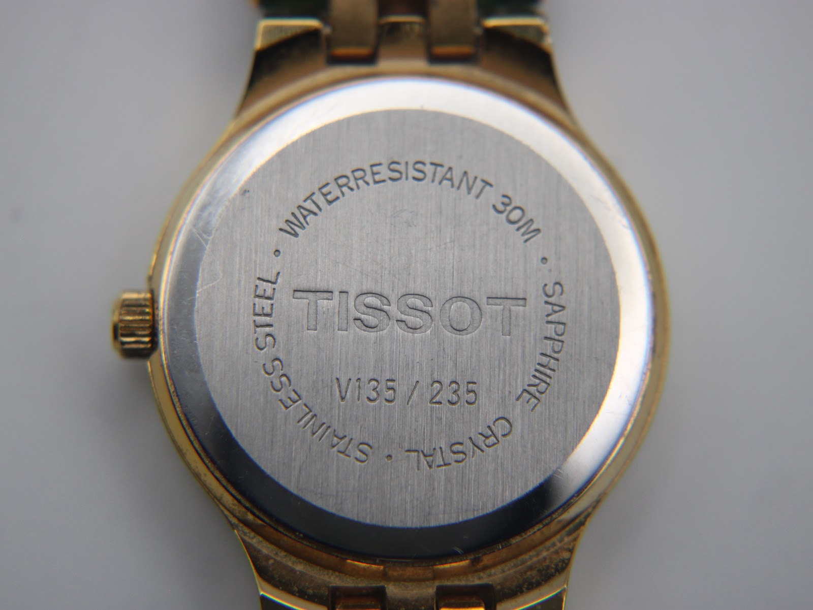 Close-up of the stainless steel case back of the Tissot Stylist, showing 'TISSOT', 'V135/235', 'Waterresistant 30m', and 'Sapphire Crystal'.