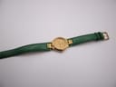 Overhead view of the Tissot Stylist watch laid flat, displaying the full length of the green leather strap.