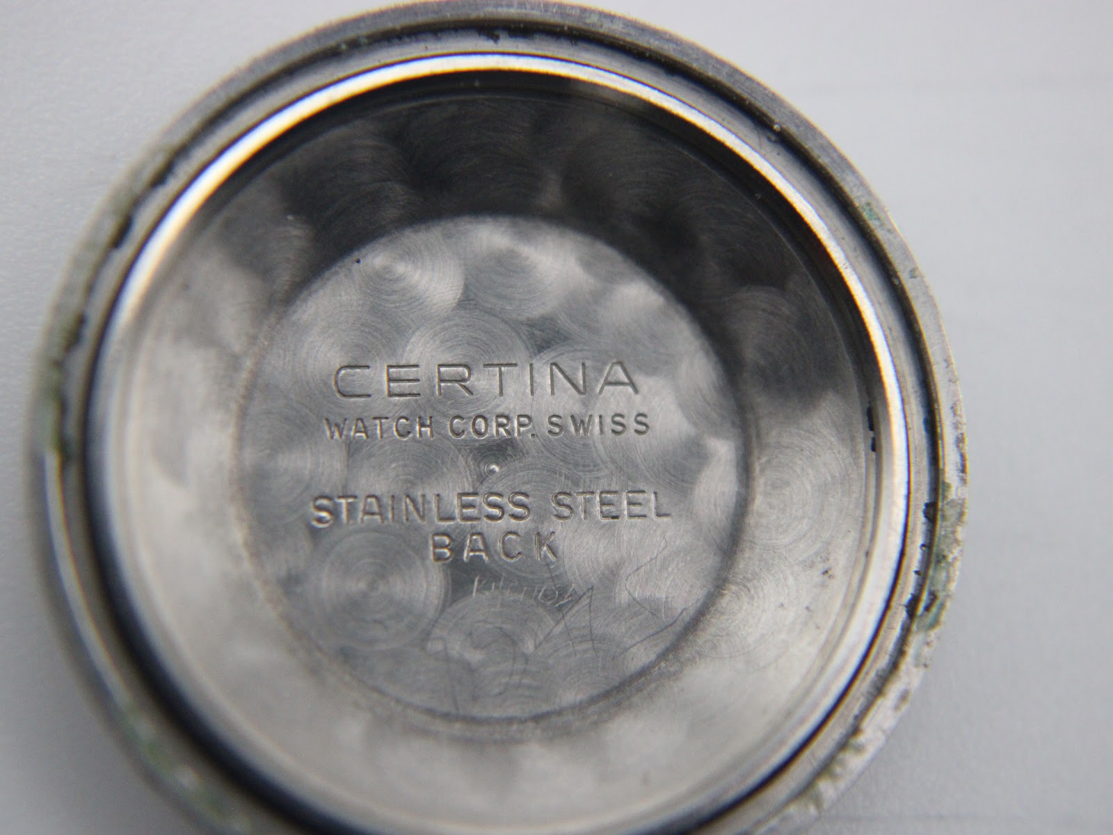Inside of the Certina watch case back, showing "CERTINA WATCH CORP. SWISS STAINLESS STEEL BACK" engraving.