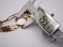 Close-up of a digital caliper measuring the watch case diameter, displaying 19.9mm, with the watch and bracelet in the background.