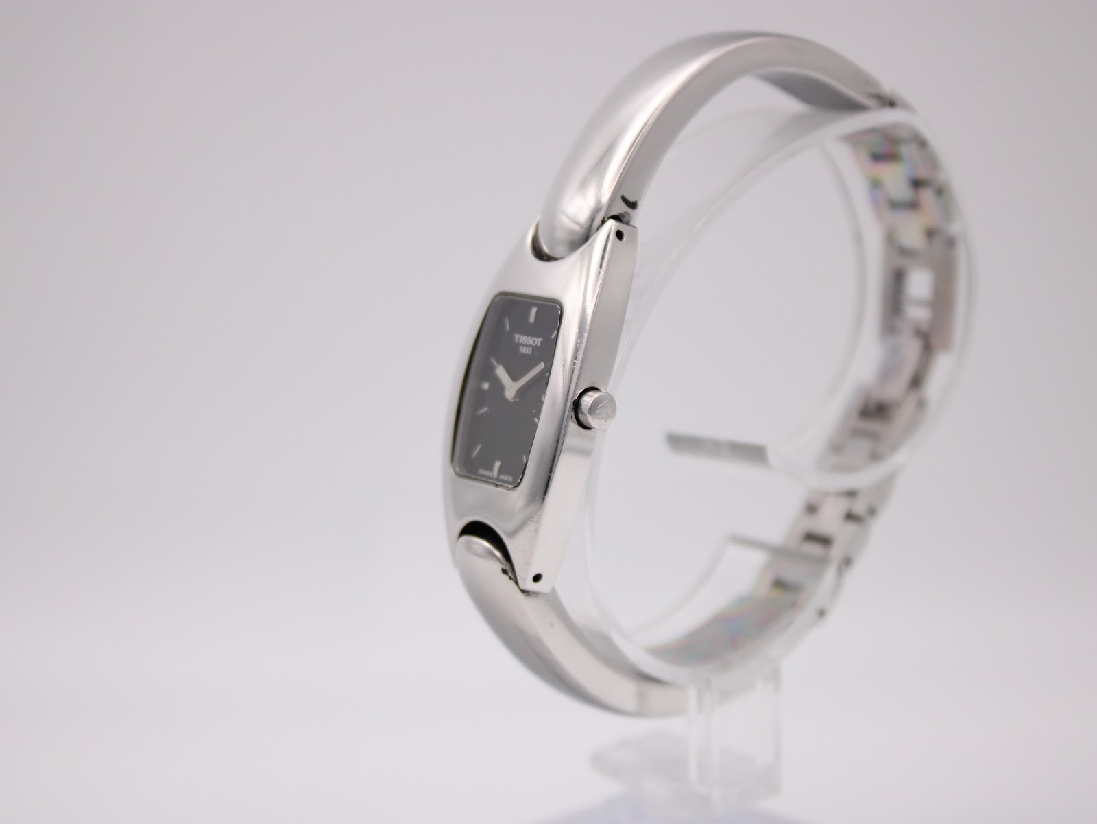 Side view of the Tissot G345 watch showcasing the curved stainless steel bangle and small black dial.