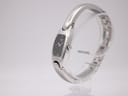 Side view of the Tissot G345 watch showcasing the curved stainless steel bangle and small black dial.