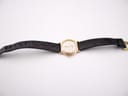 Top-down view of the Raymond Weil watch with black leather strap laid flat.
