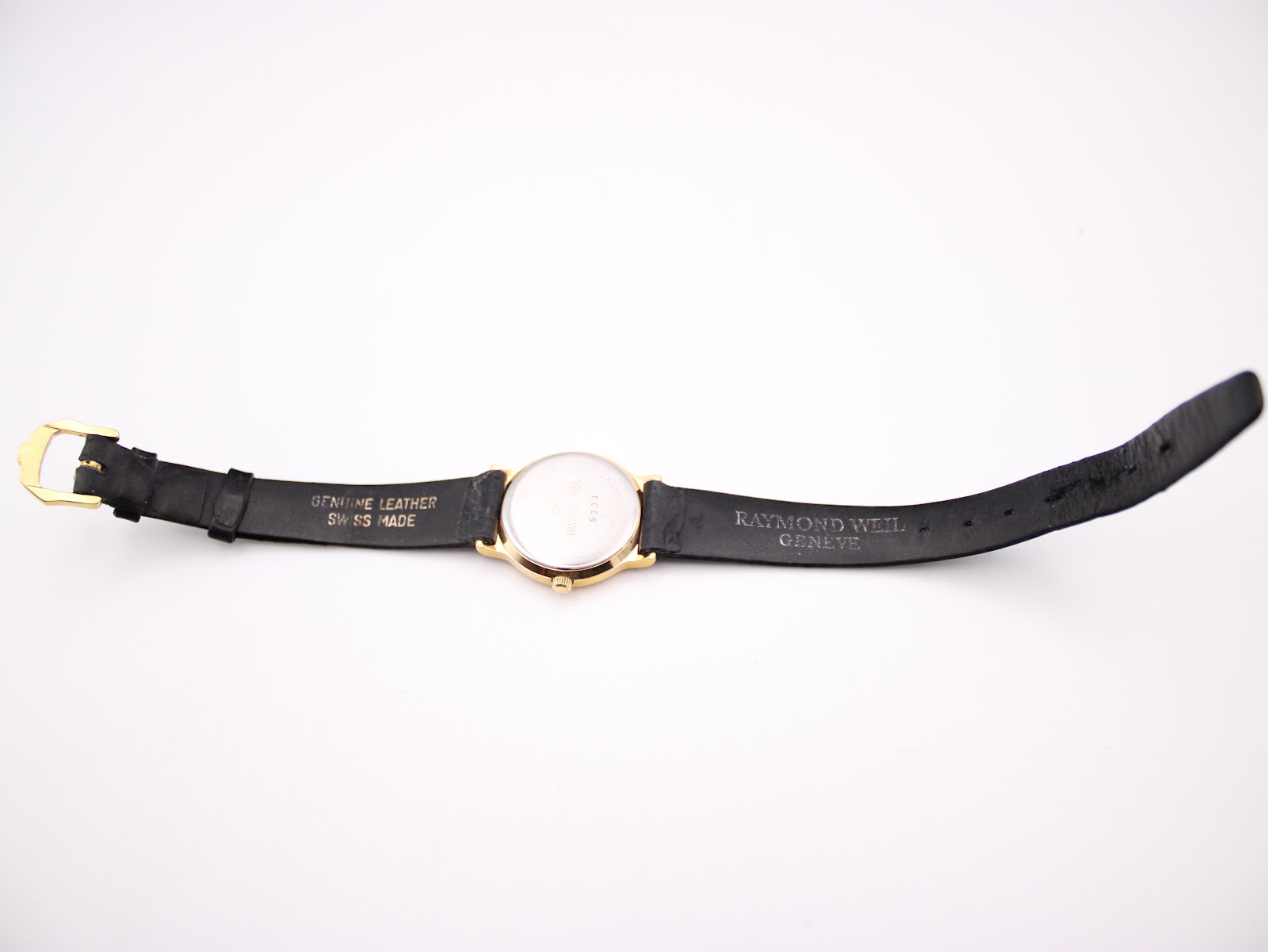 Back view of the Raymond Weil watch with strap laid flat, showing 'GENUINE LEATHER SWISS MADE' on strap.