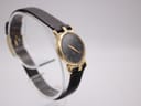 Another angled view of the Gucci 3400 L watch, highlighting the gold-tone case and black dial.