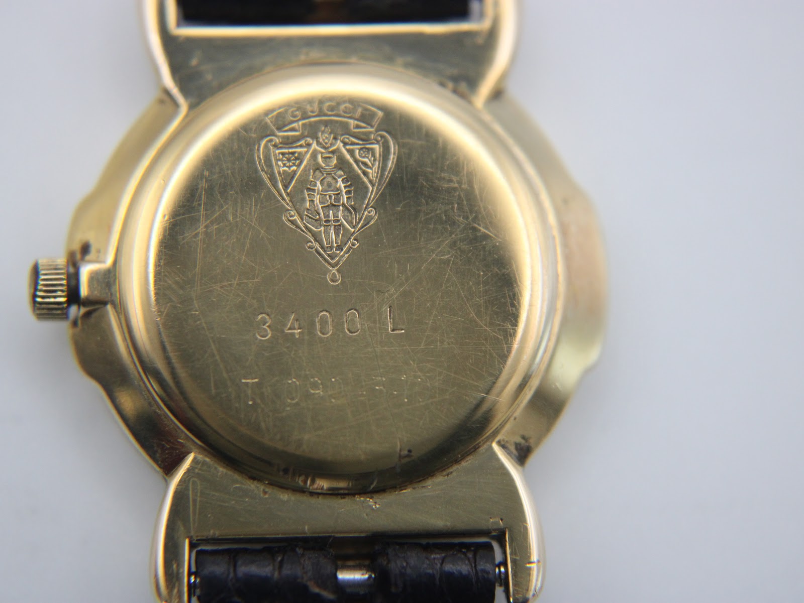Close-up of the gold-tone case back of the Gucci 3400 L, showing the Gucci crest and model number engraving.