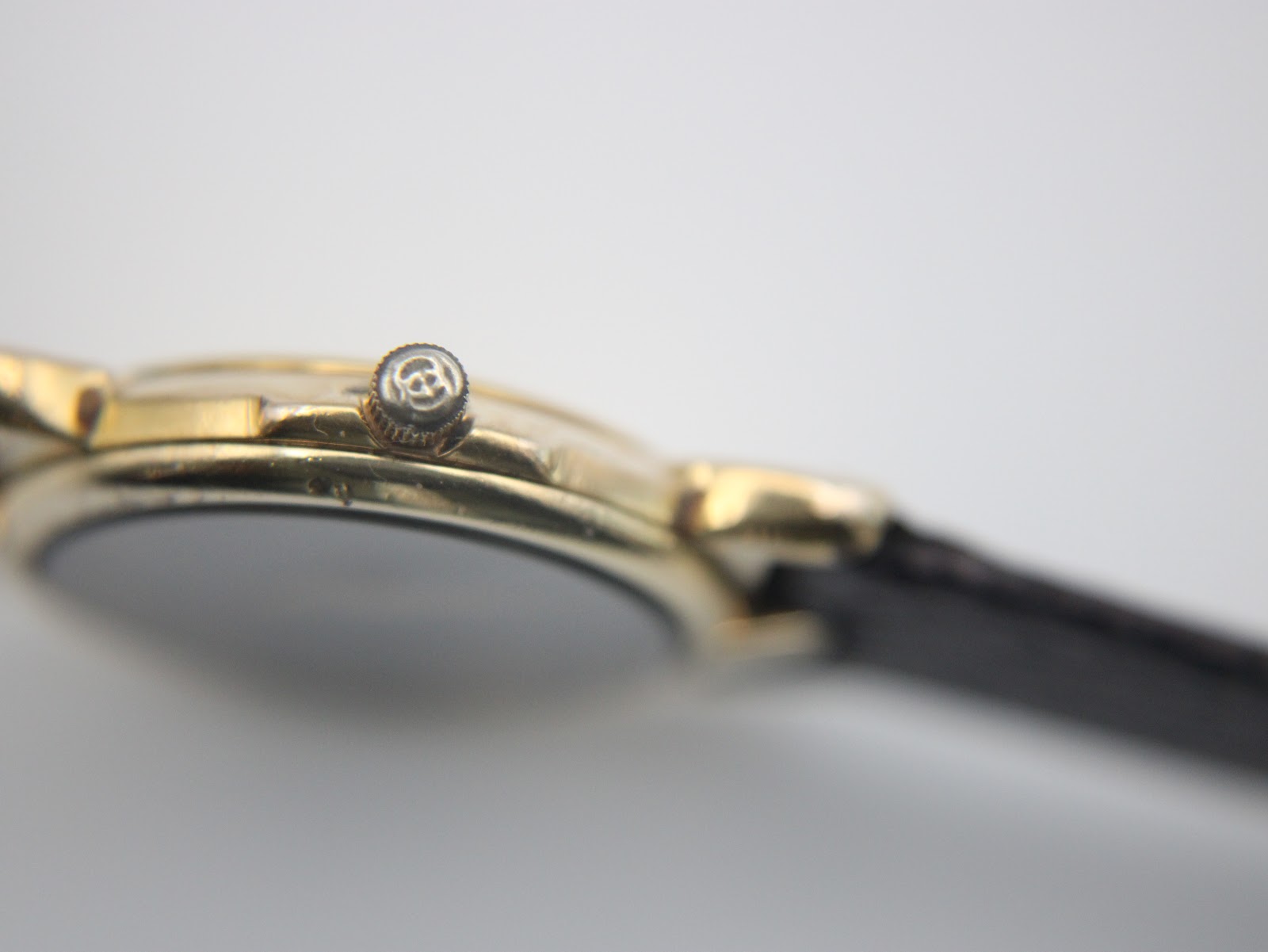Close-up side view of the Gucci 3400 L watch crown with the Gucci interlocking G logo.
