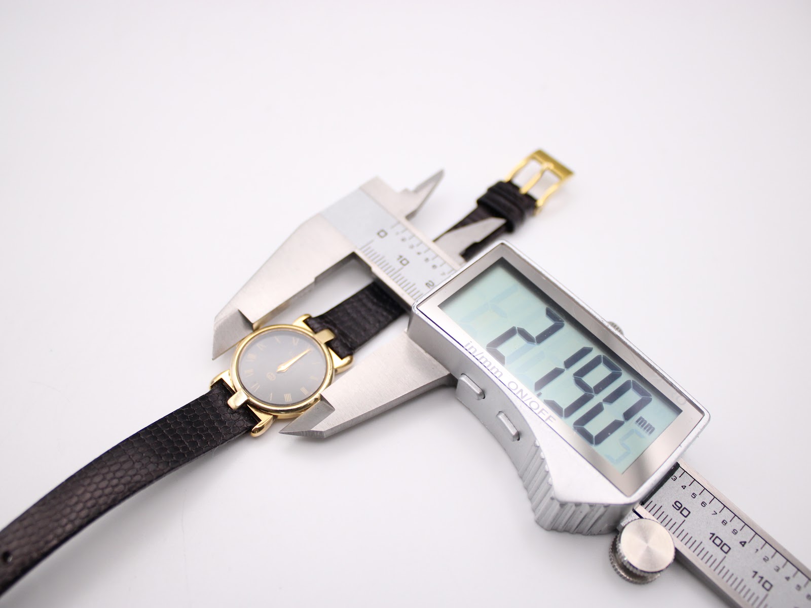 Digital caliper measuring the case diameter of the Gucci 3400 L watch, showing 21.90mm.
