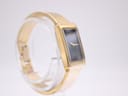 Side view of the Michel Herbelin watch on a stand, highlighting the integrated gold tone bracelet.