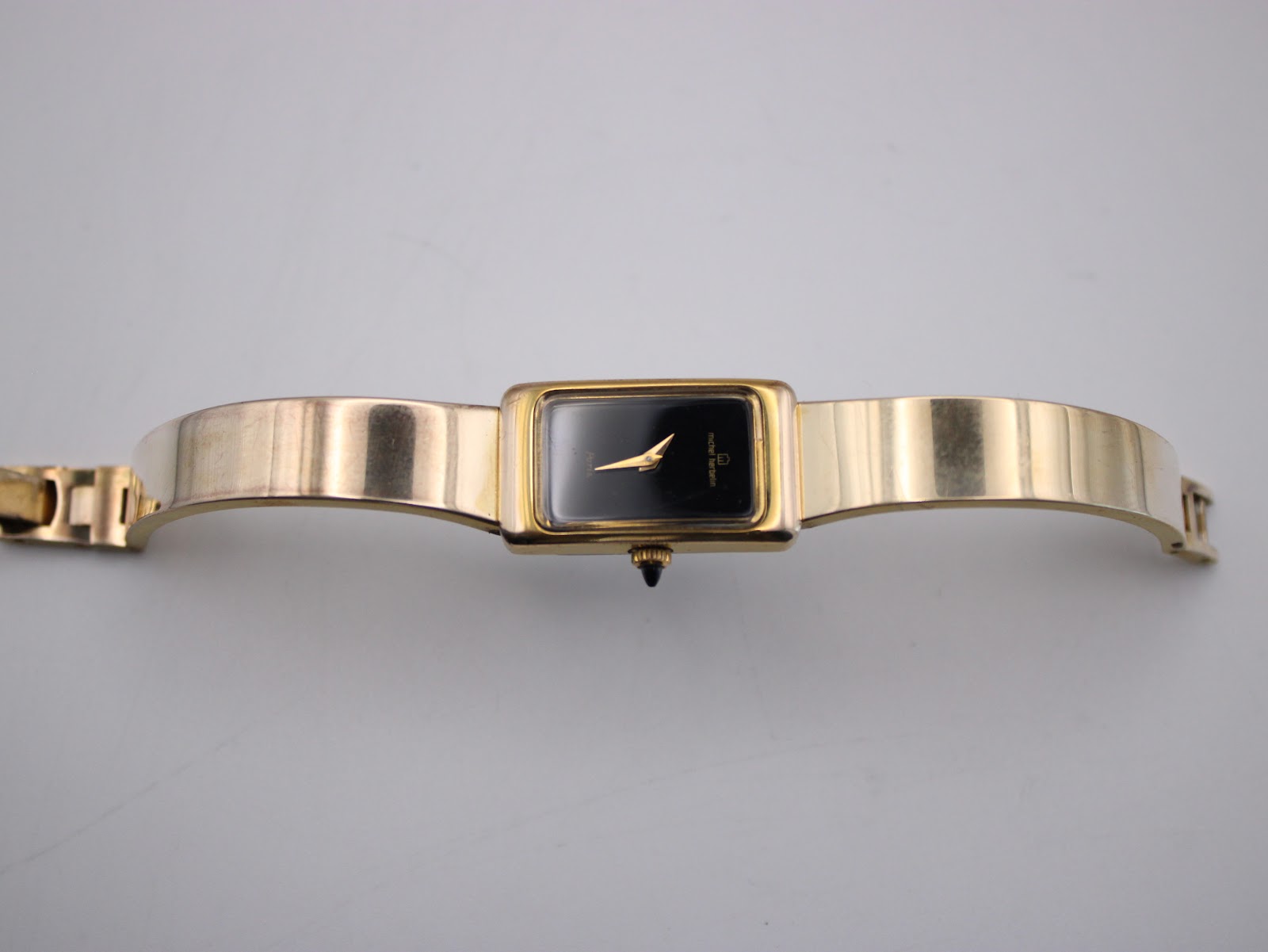 Top-down view of the Michel Herbelin watch with its integrated gold tone bracelet extended.