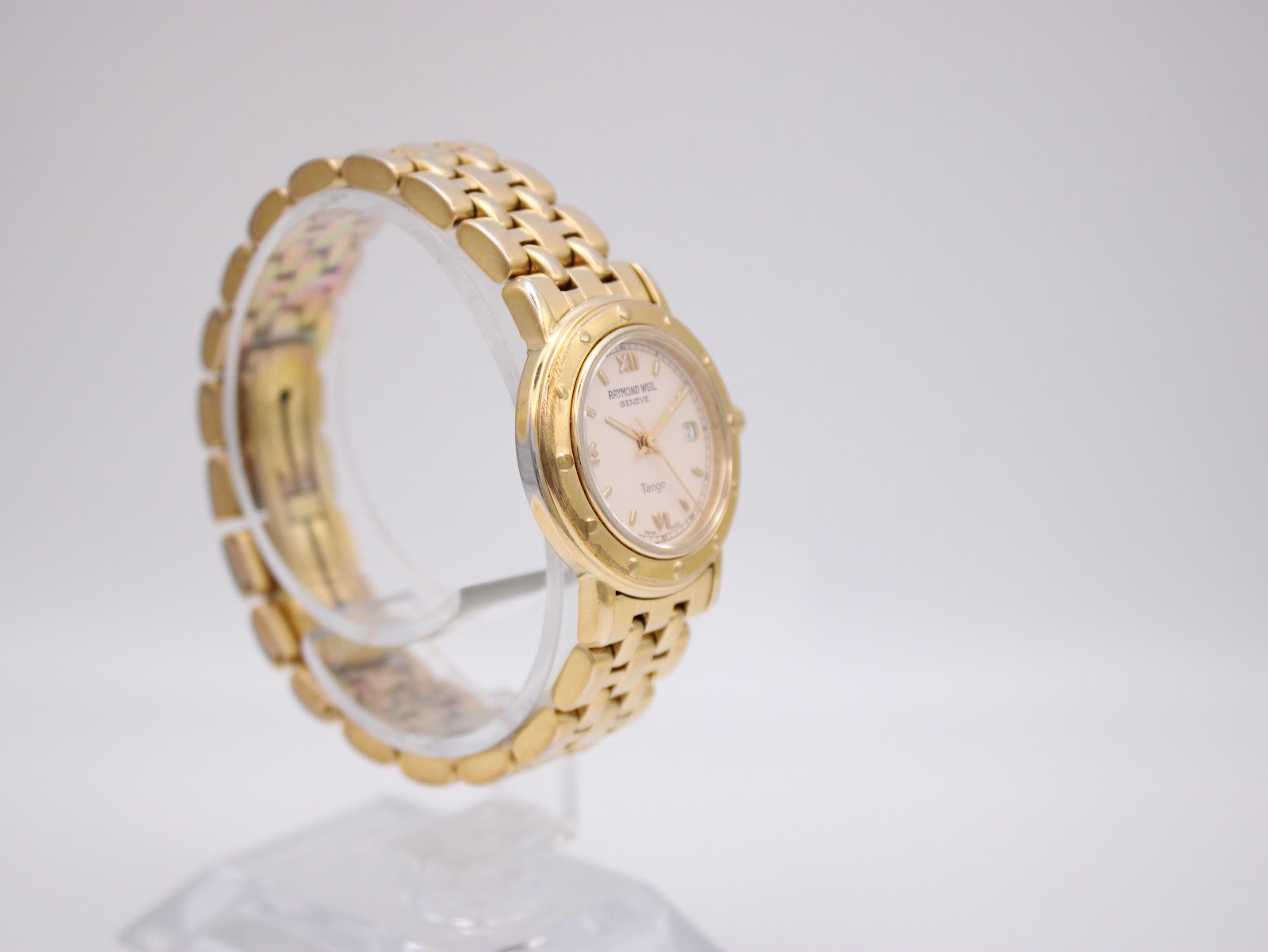 Another angled view of the Raymond Weil Tango on a display stand, highlighting the watch's profile and bracelet.