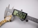 Digital caliper measuring the Raymond Weil Tango case, displaying a precise diameter of 28.04 mm.