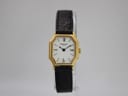 Front view of the Raymond Weil 737 watch, showing the gold octagonal case, white dial with Roman numerals, and black leather strap.