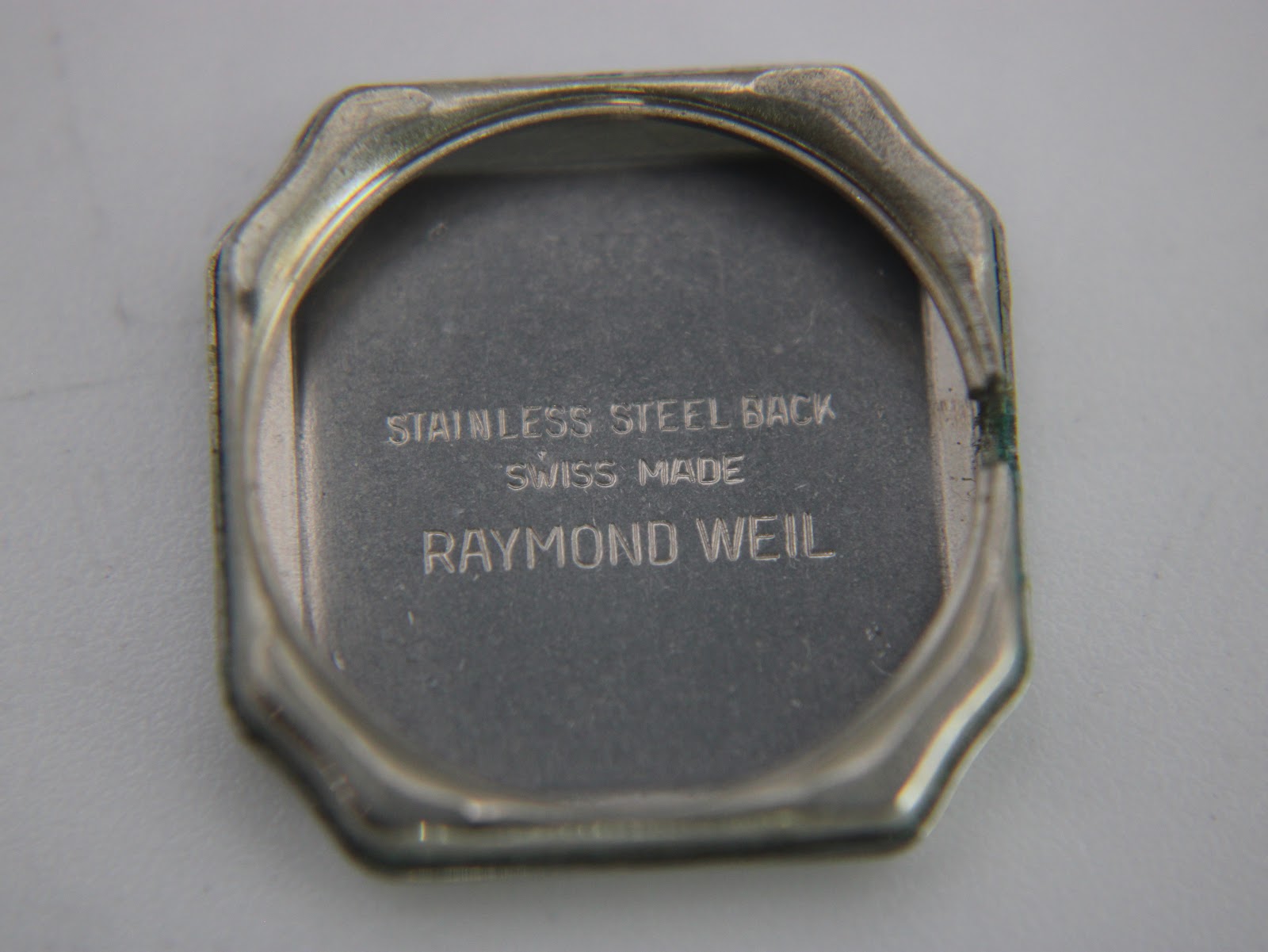 Inside view of the case back, engraved with 'STAINLESS STEEL BACK', 'SWISS MADE', and 'RAYMOND WEIL'.