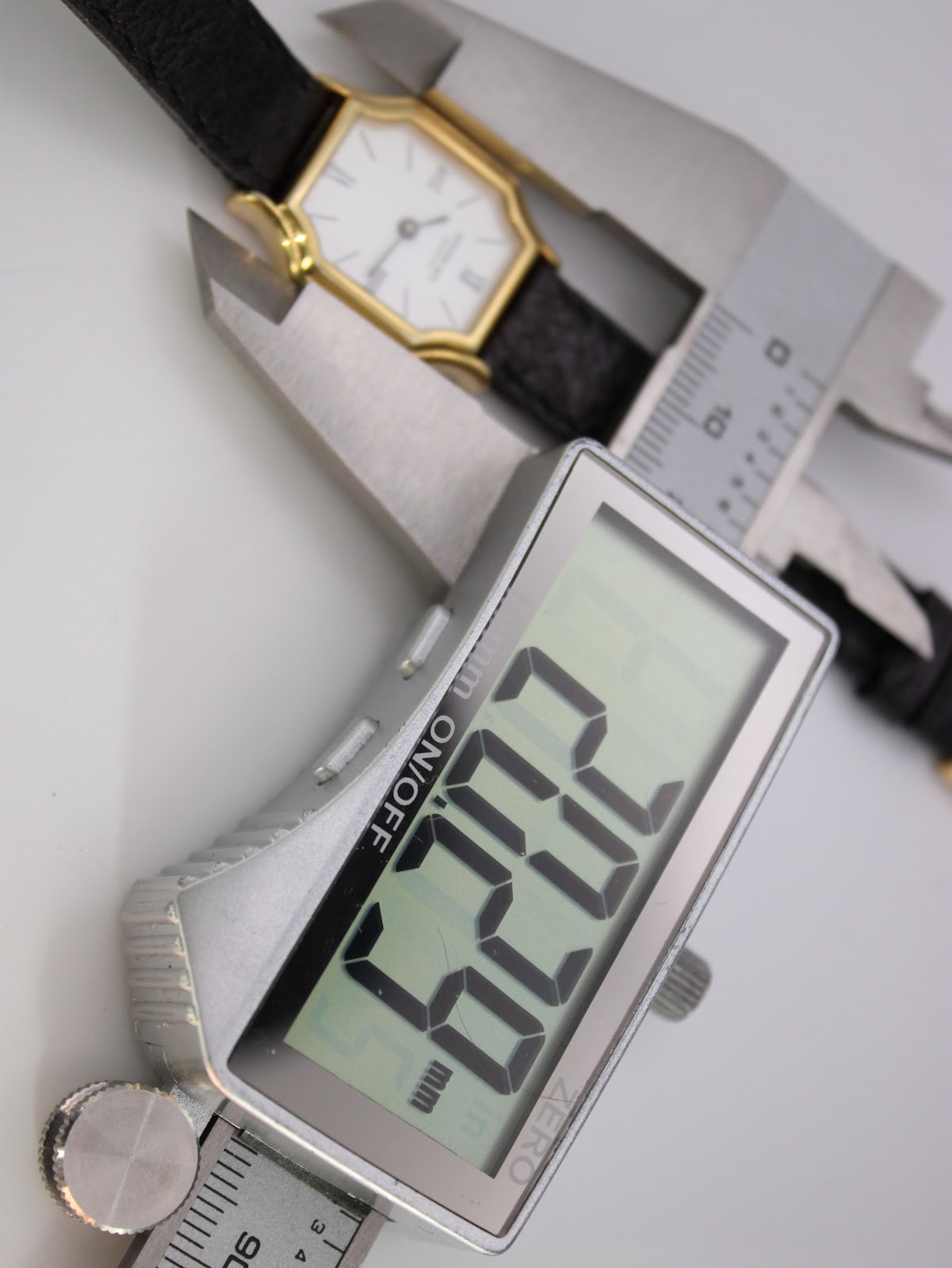 The watch being measured by a digital caliper, displaying a case size measurement of 22.3mm.
