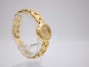 Left side angle view of the Alfex gold watch on a display stand, highlighting the bracelet's texture.