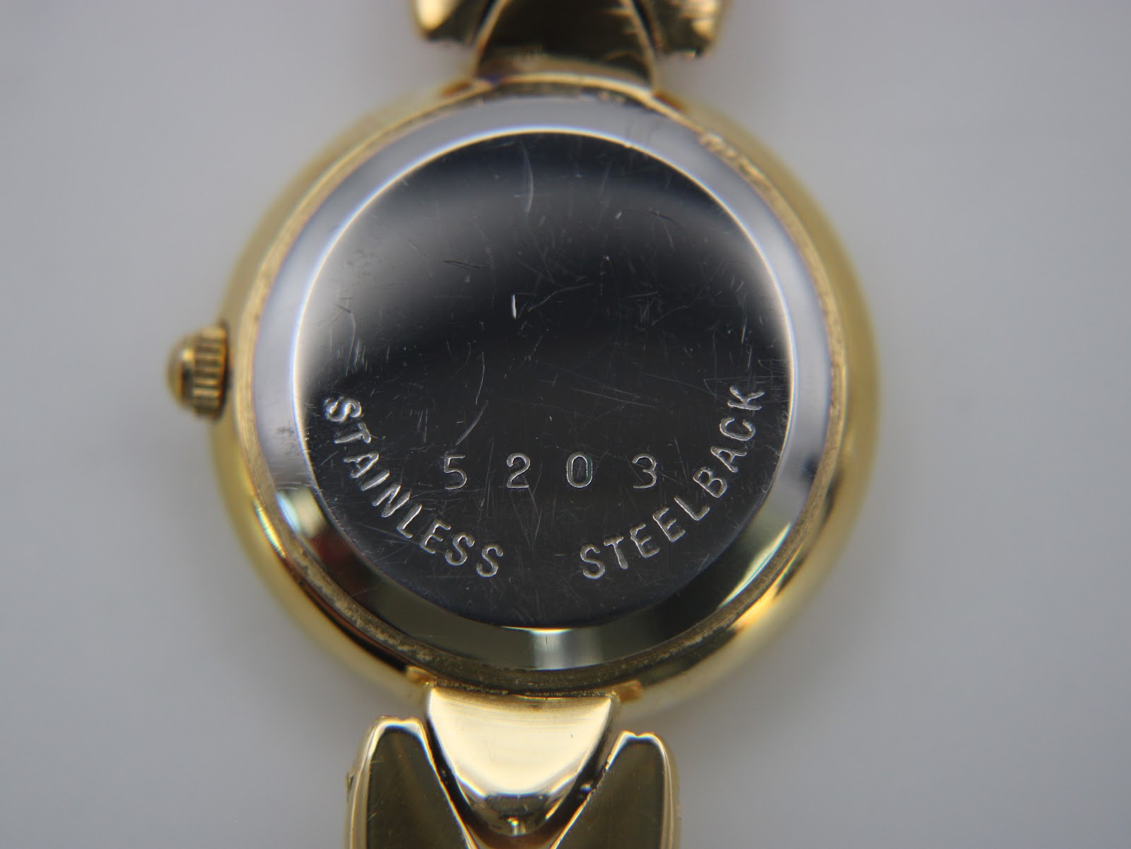 Close-up of the stainless steel case back with "5203" serial number and "STAINLESS STEELBACK" engraving.