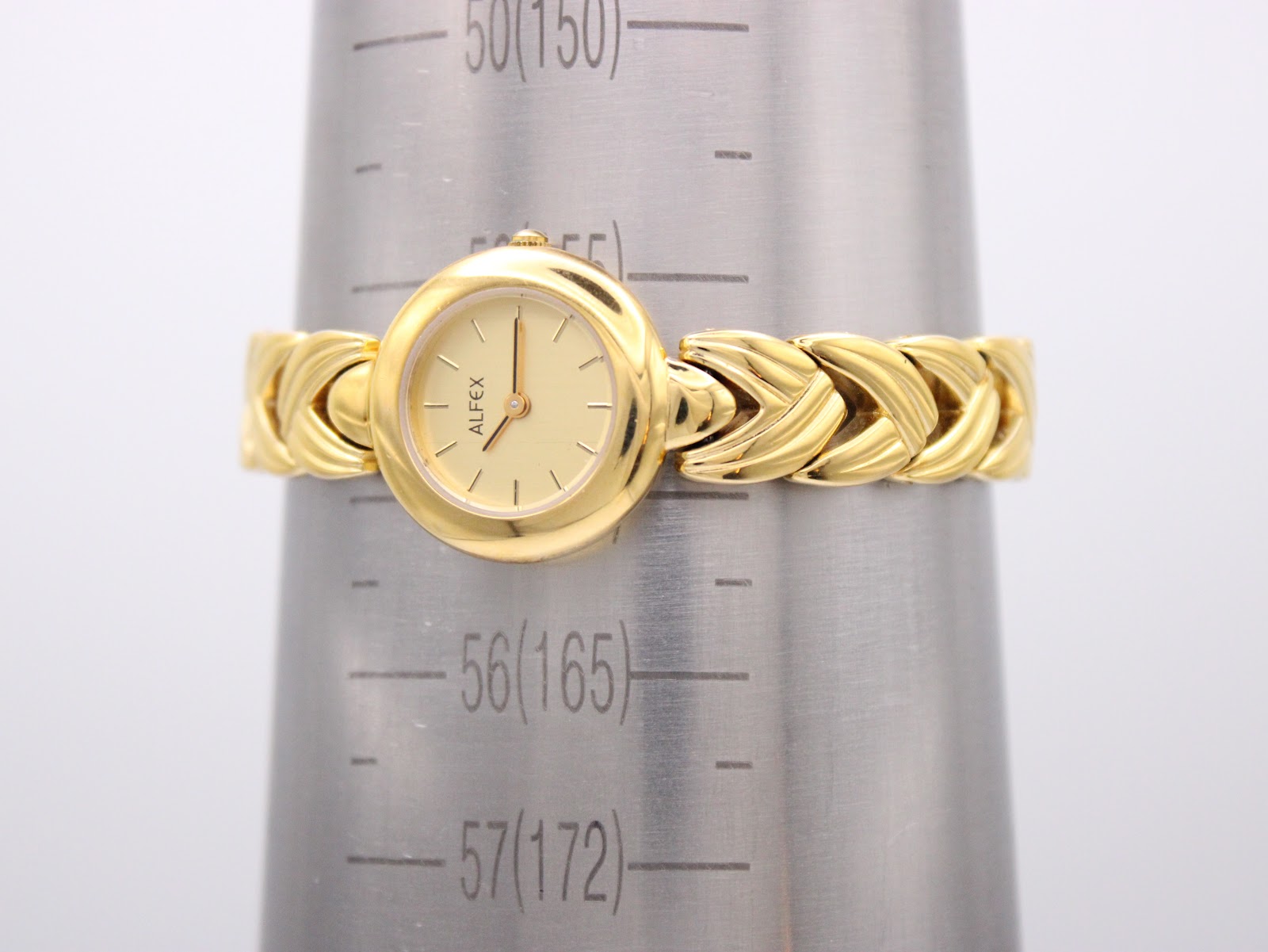 Alfex watch on a wrist sizing gauge, indicating a maximum wrist circumference of approximately 16.5cm.
