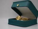Alfex watch resting inside a teal presentation box with a gold crown emblem.