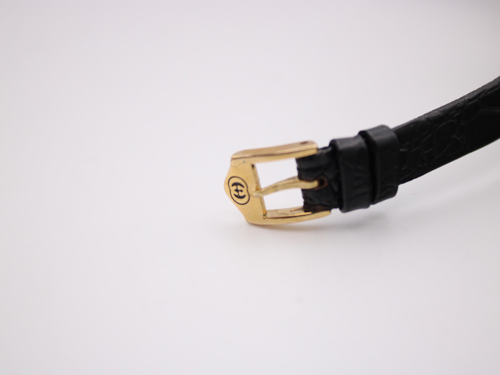 Close-up of the gold-tone buckle, clearly showing the embossed Gucci logo.