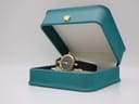 Angled view of the Gucci 2000L watch resting inside an open turquoise display box with a crown emblem.